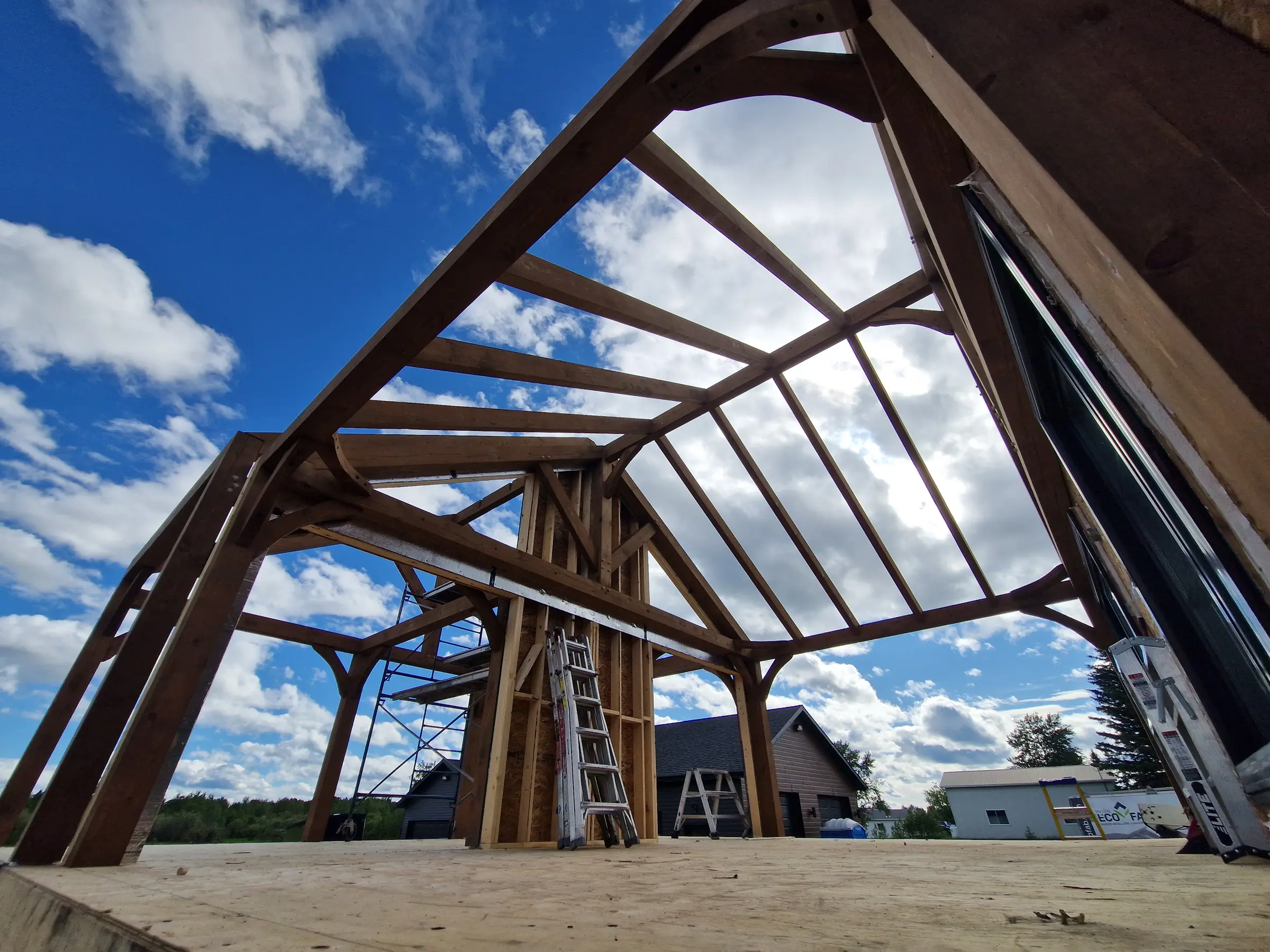 Grande structure en bois en cours de montage sous un ciel bleu