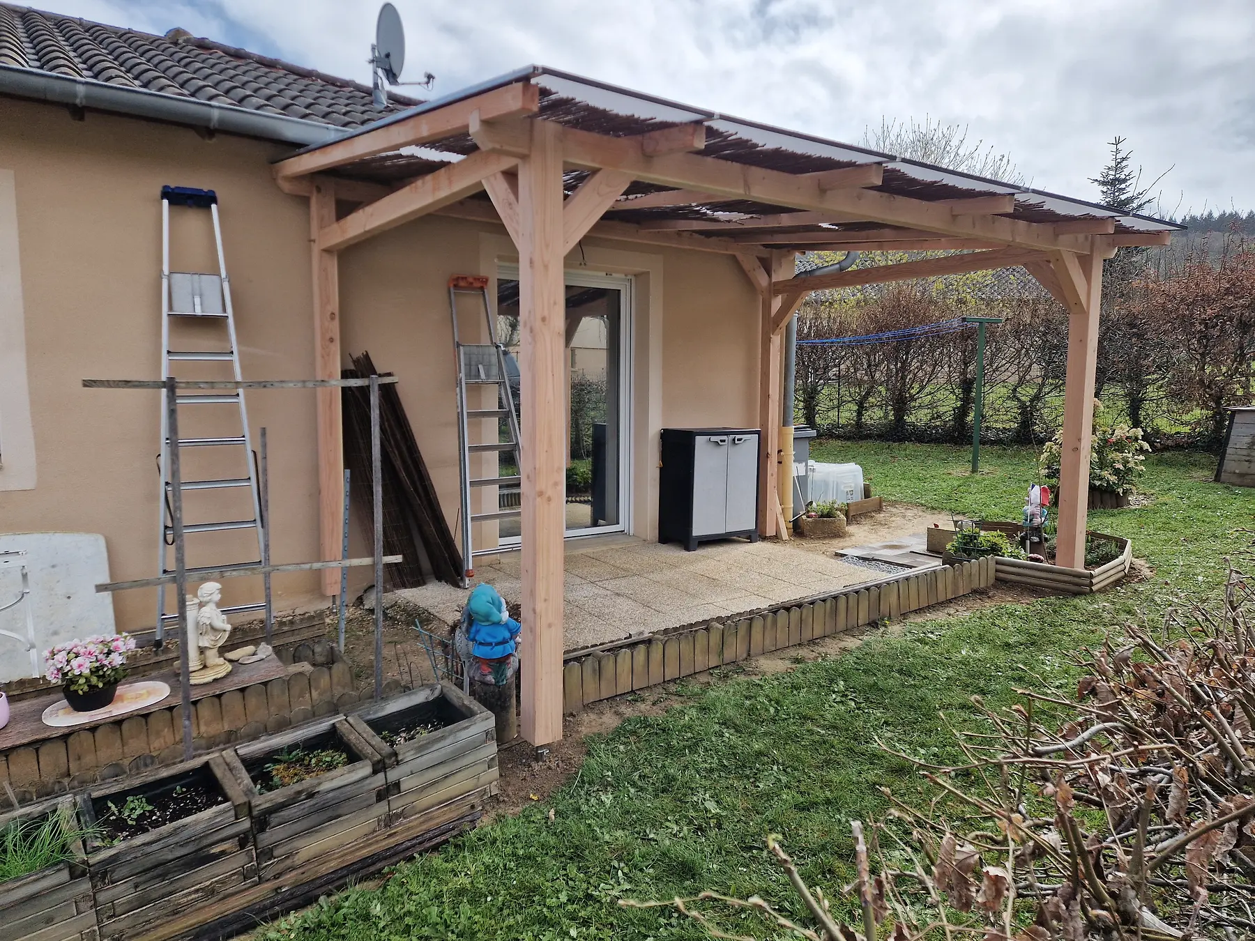 Pergola en bois construite devant la terrasse d’une maison