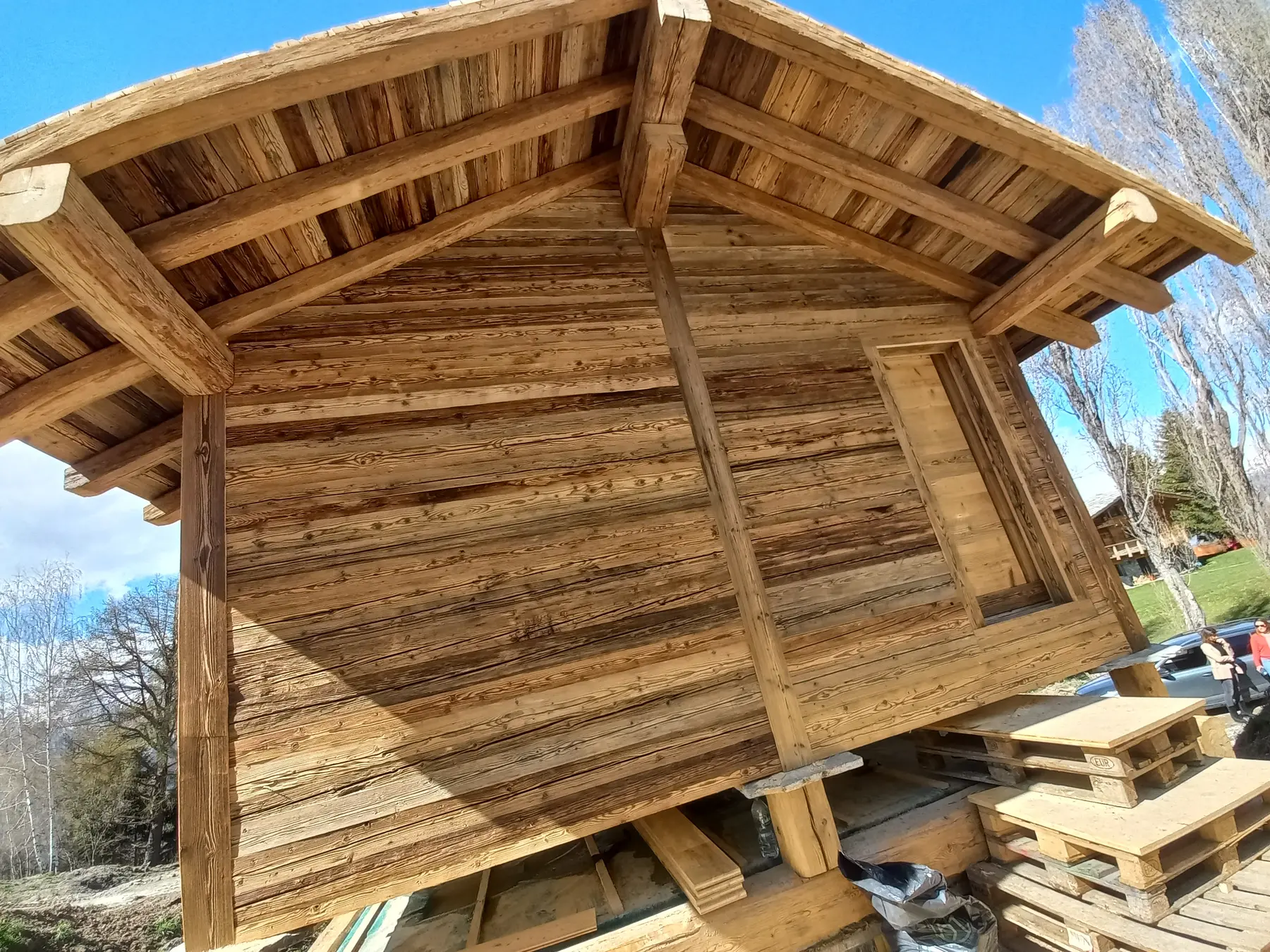 Petite construction en bois en cours de réalisation dans un paysage de montagne