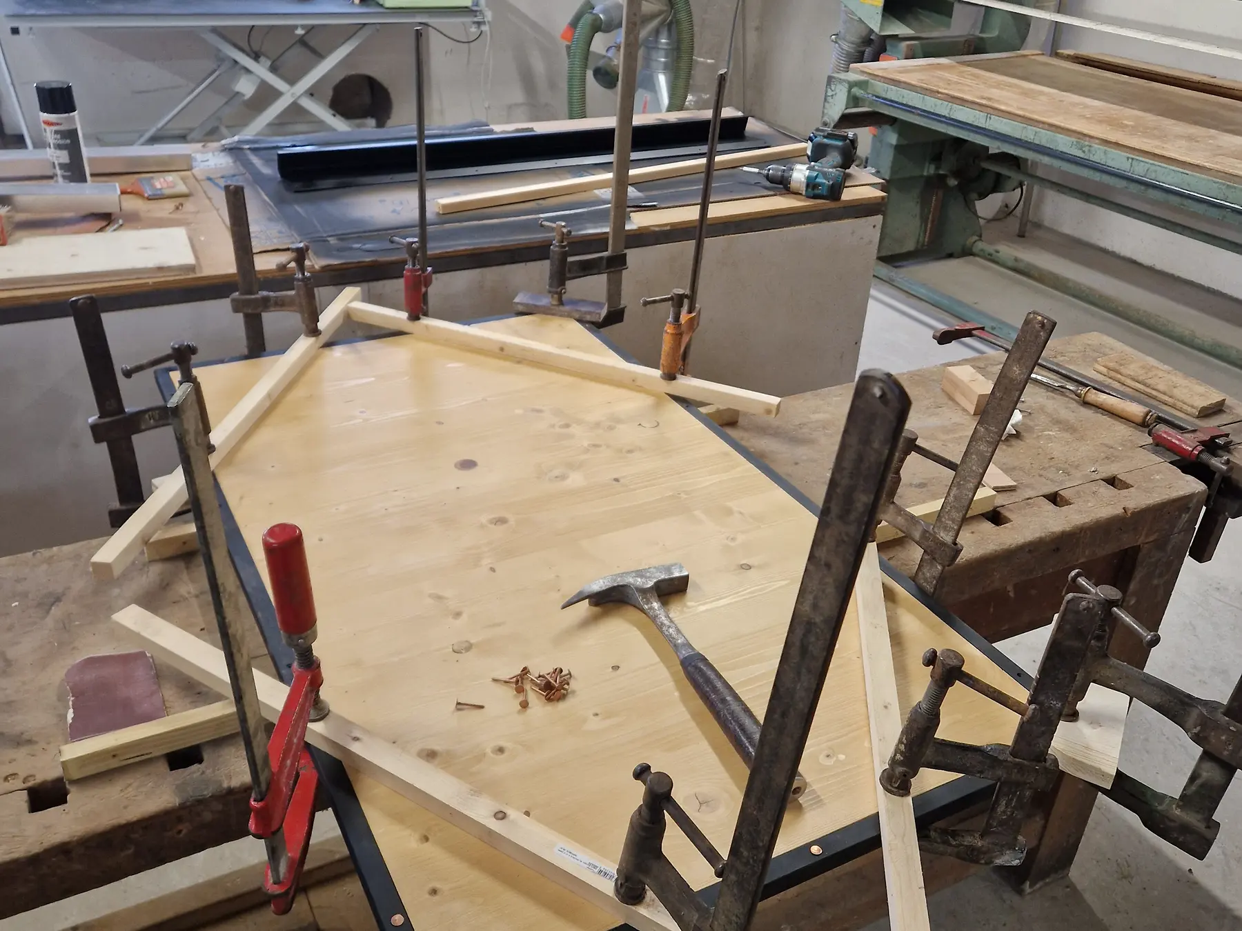 Panneau de mobilier en bois assemblé avec plusieurs serre-joints dans l’atelier